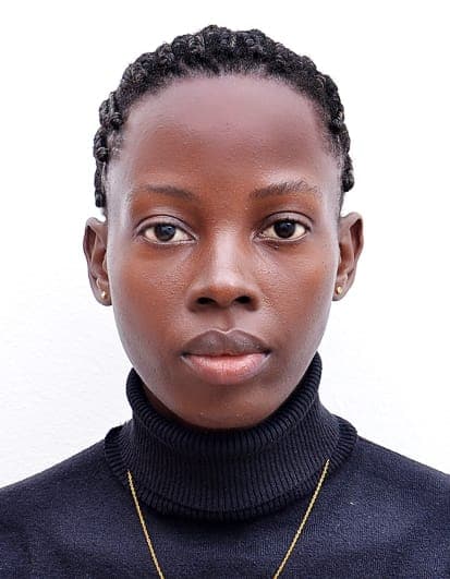 Young Black woman with braided hair, wearing a black turtleneck and gold necklace.